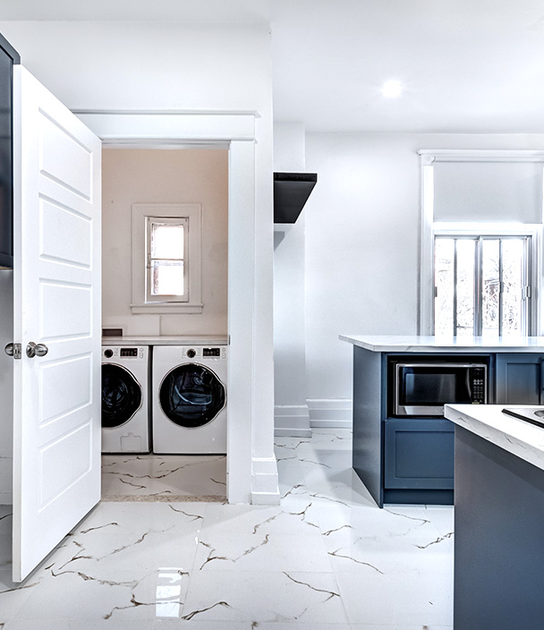 Modern home interior with a kitchen and a nearby laundry nook with a washer and dryer